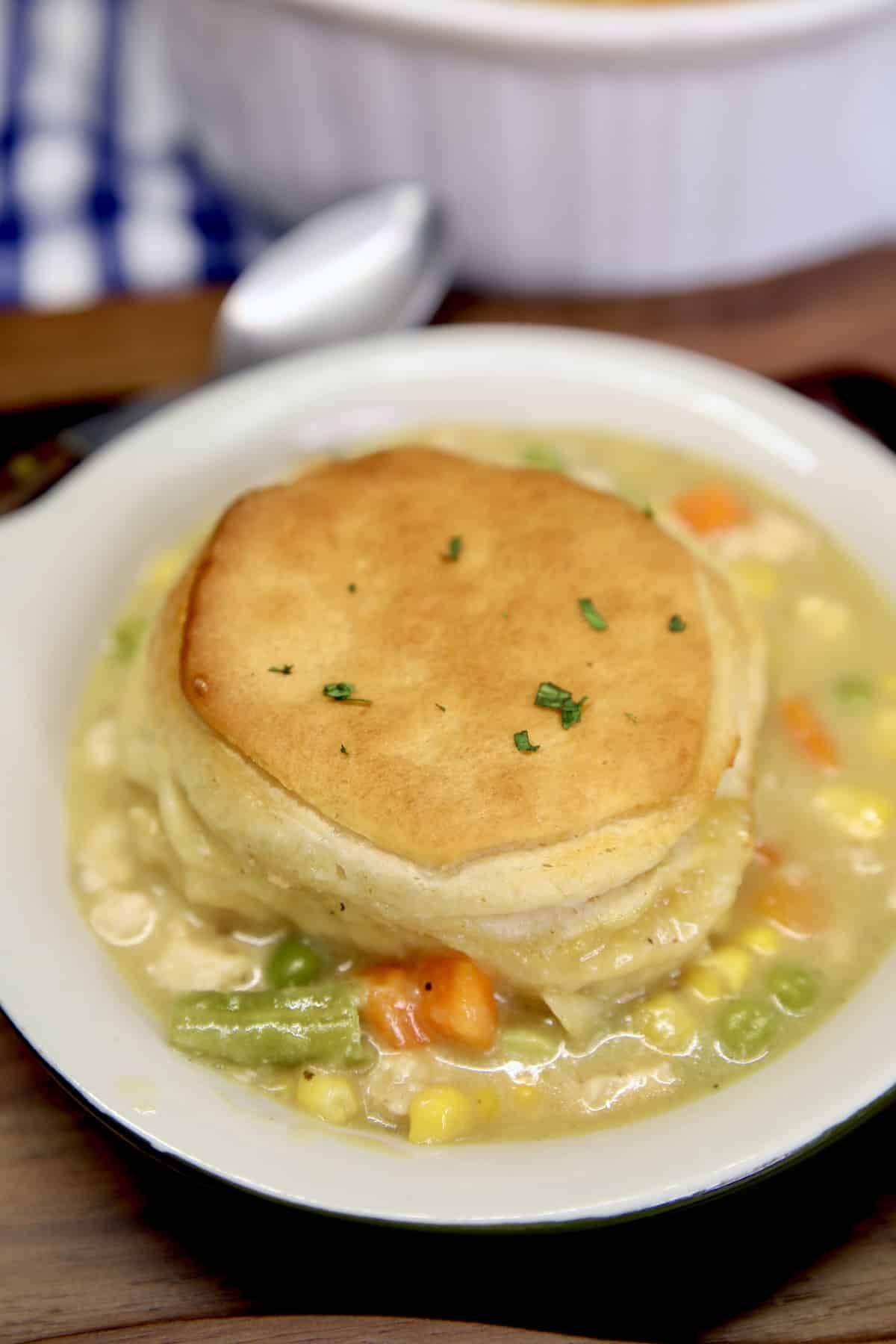 Chicken pot pie casserole in a bowl with biscuit on top.