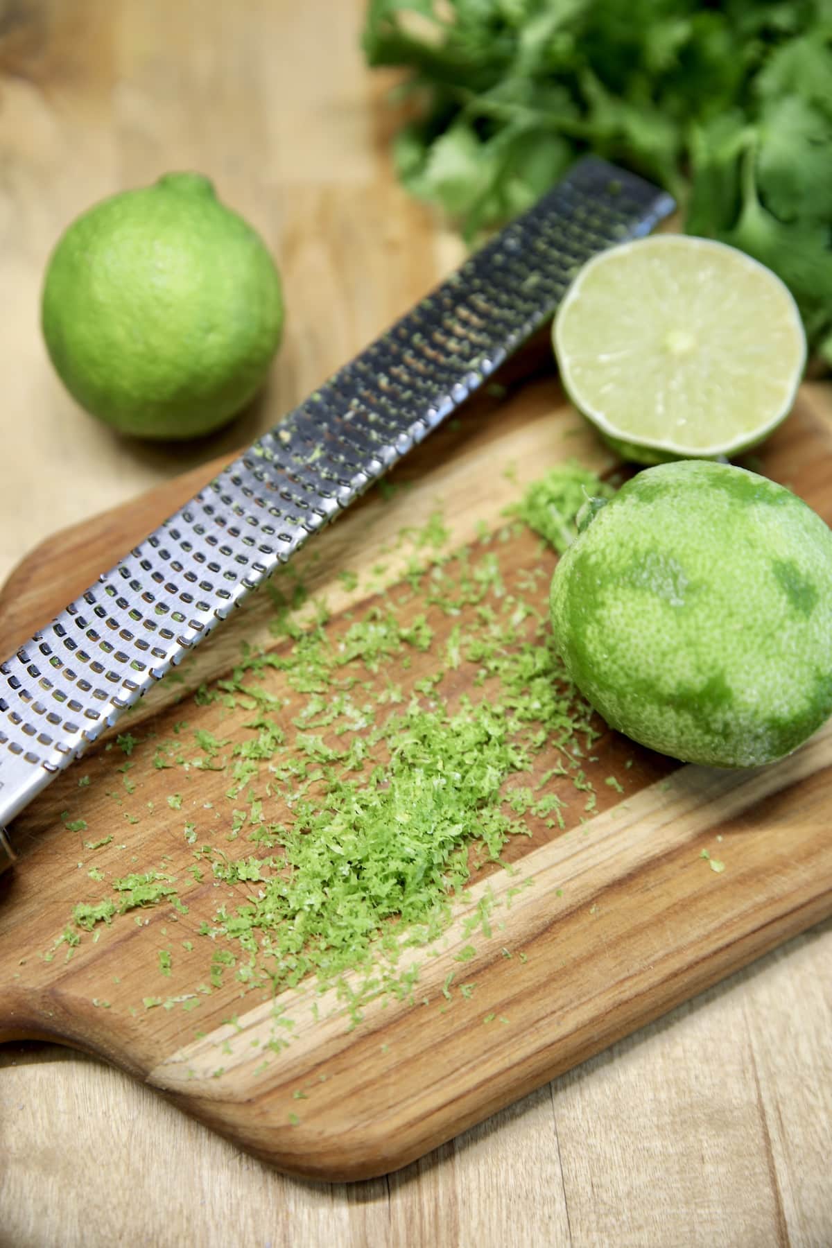 Zesting limes on a cutting board.