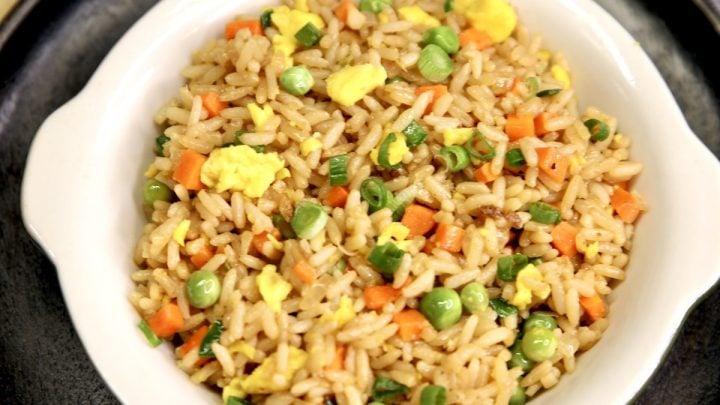 Bowl of fried rice with carrots, peas, eggs.