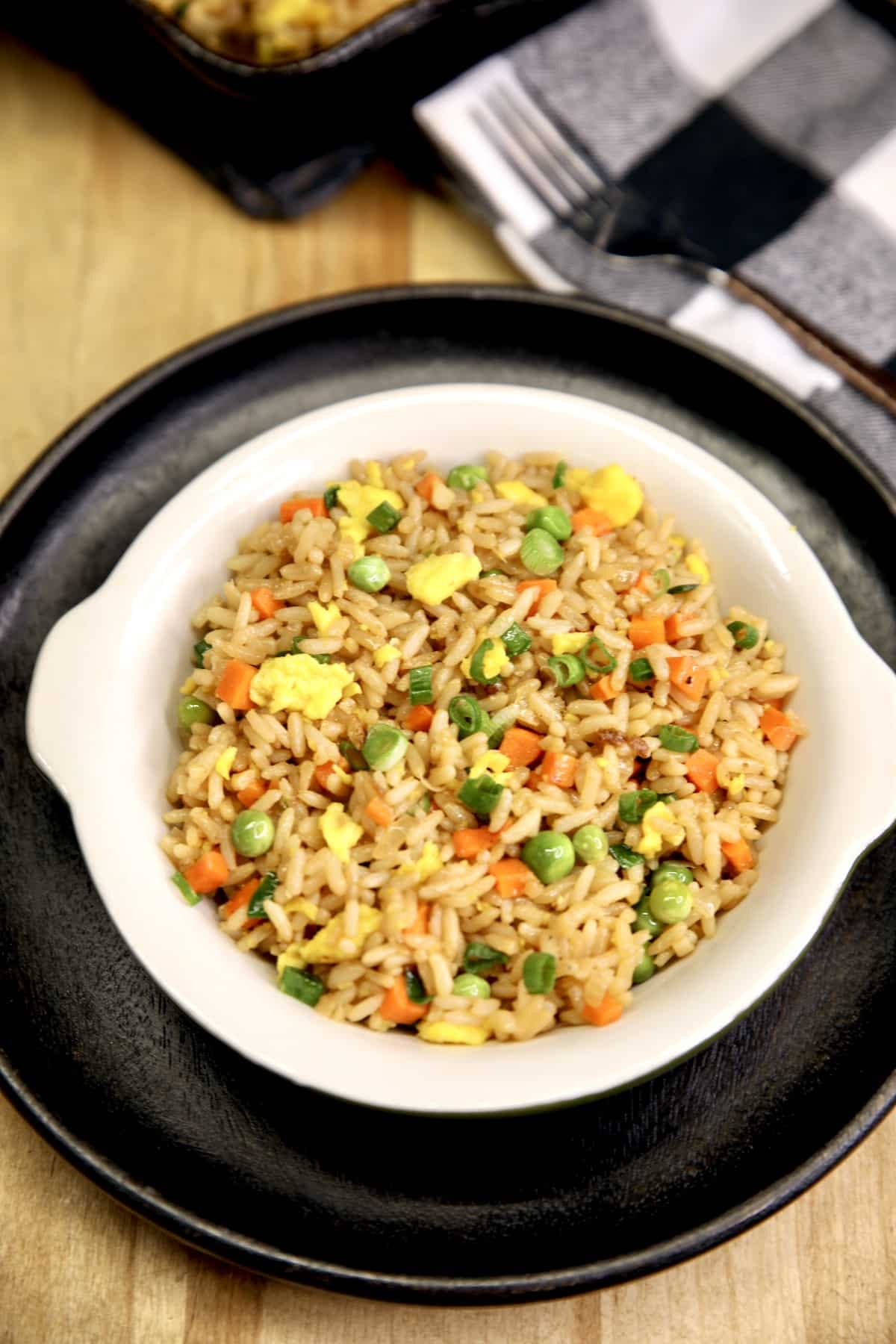 Egg Fried Rice in a bowl on a black plate.