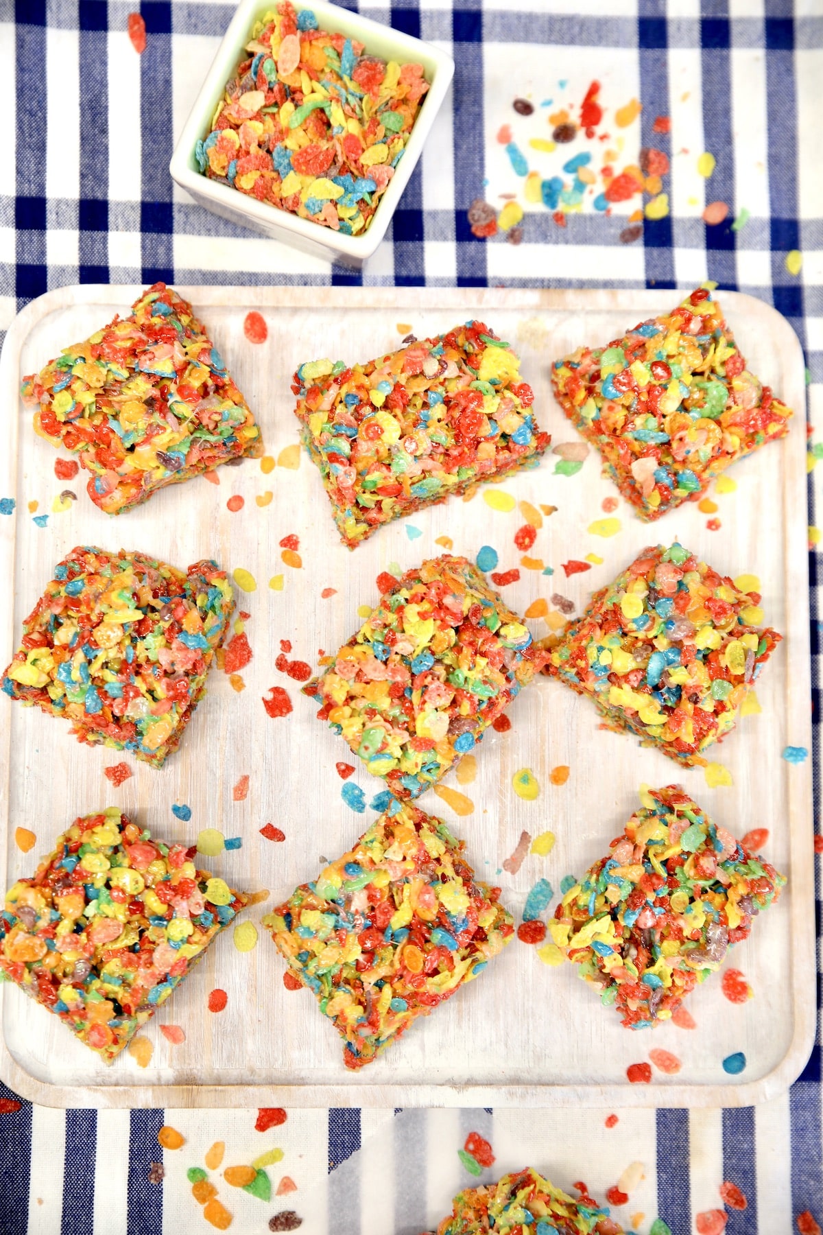 Fruity pebbles bars cut into squares on a platter.