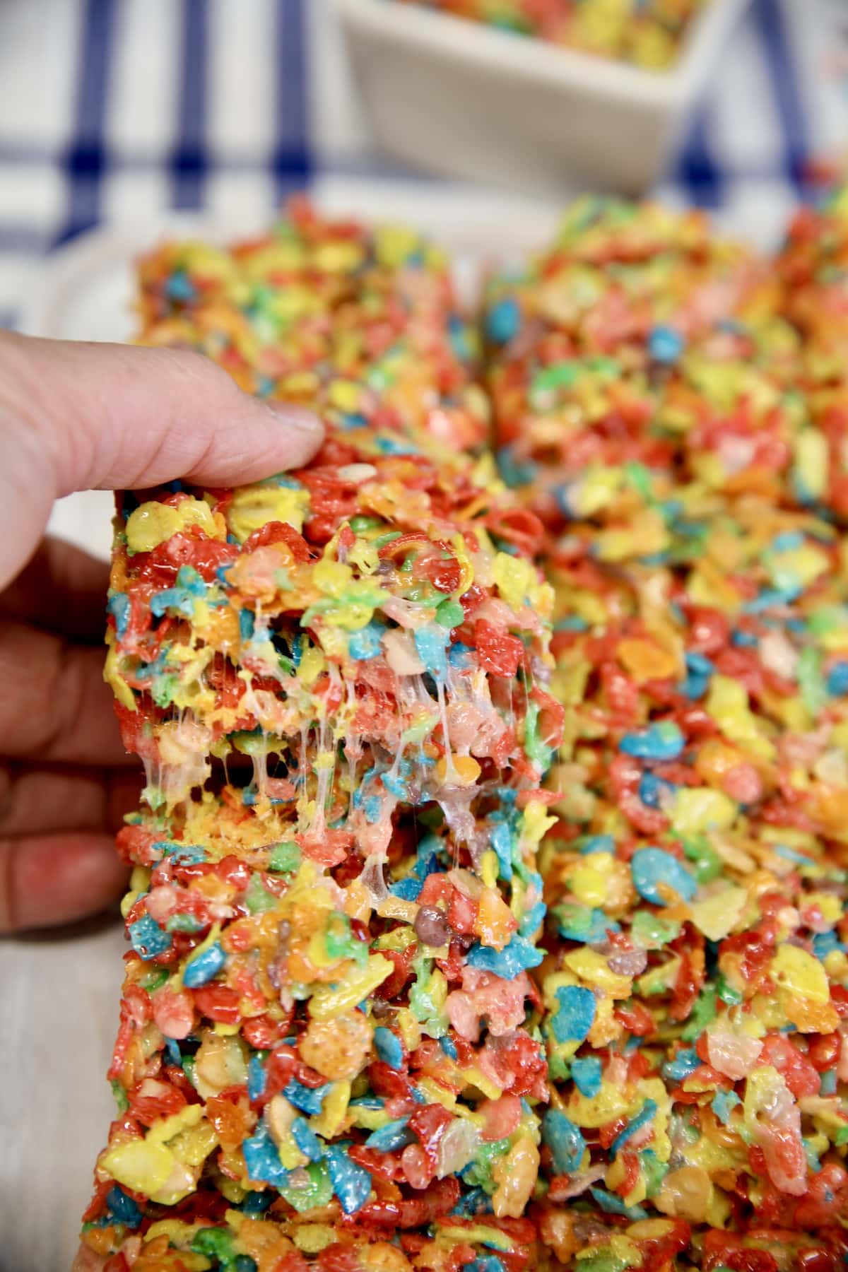 Fruity Pebbles treat bars, pulling apart after slicing.
