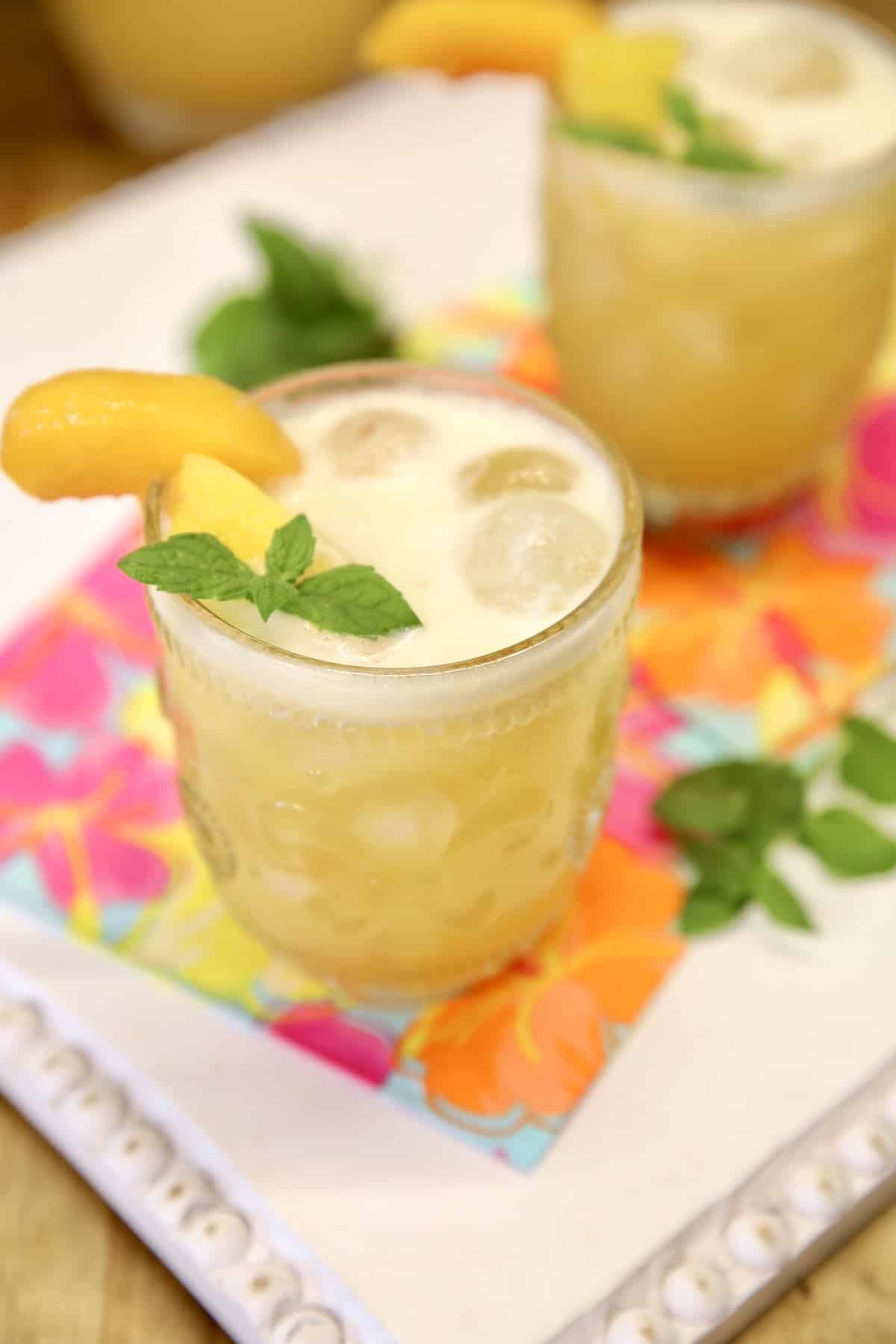 2 glasses of pineapple peach cocktails.