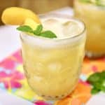 Pineapple peach moscato punch in a glass with peach, pineapple and mint garnish.