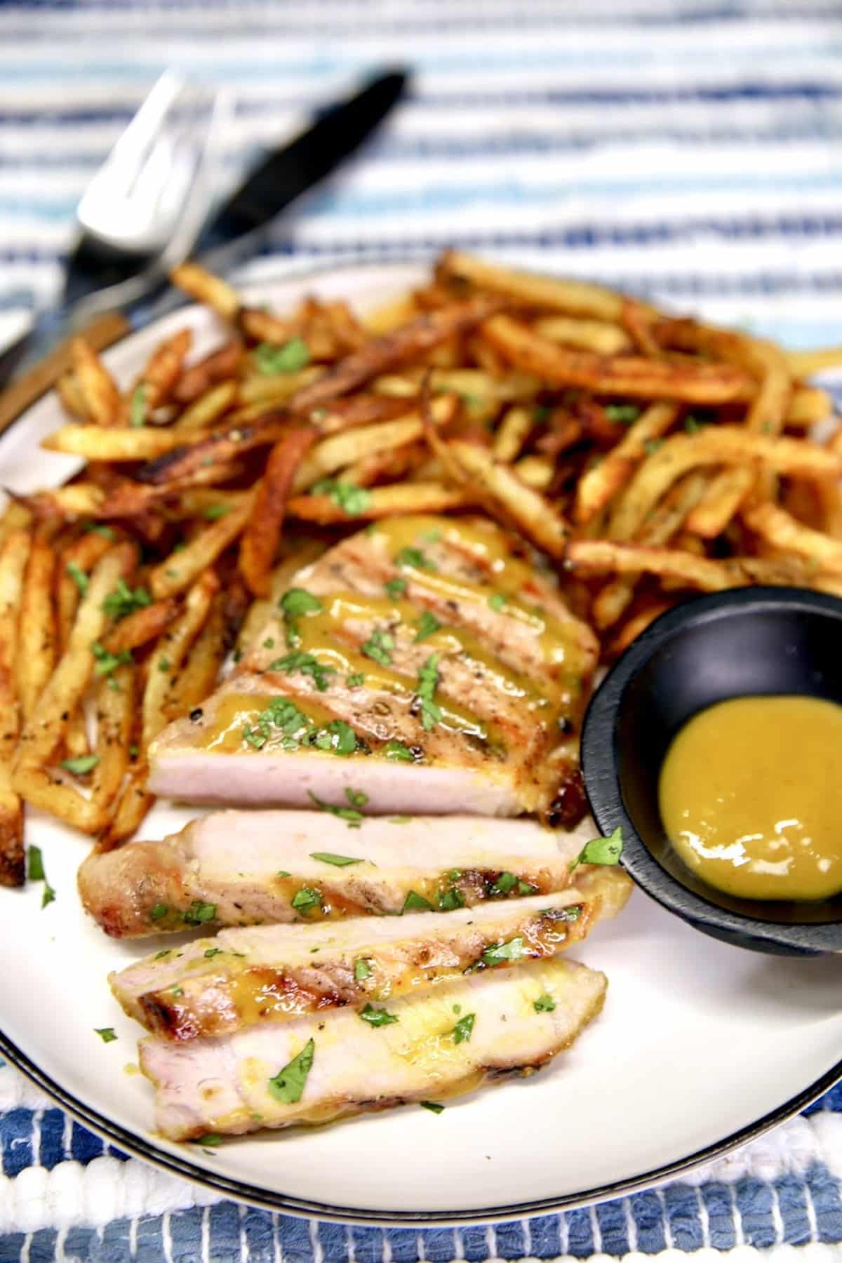 Mustard Pork Chop on a plate with fries.