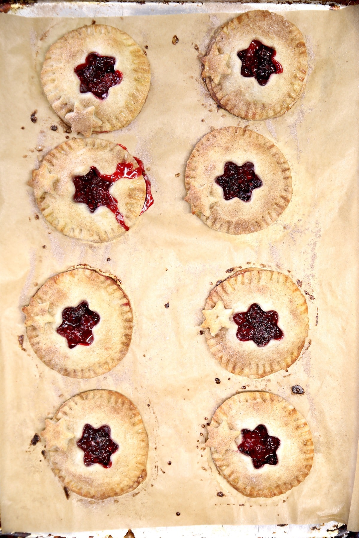 Baked blackberry hand pies on a rimmed baking sheet.