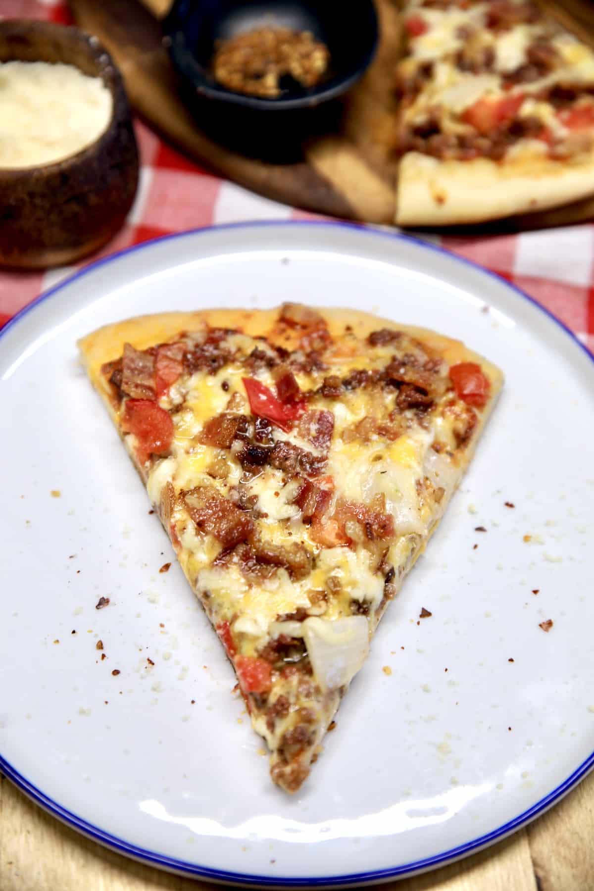 Slice of bacon cheeseburger pizza on a plate.