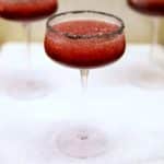 Black cherry margarita in a coupe glass with black lava salt rim.