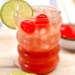 Cherry Limeade Moscato Punch in a glass with cherries and lime slice.