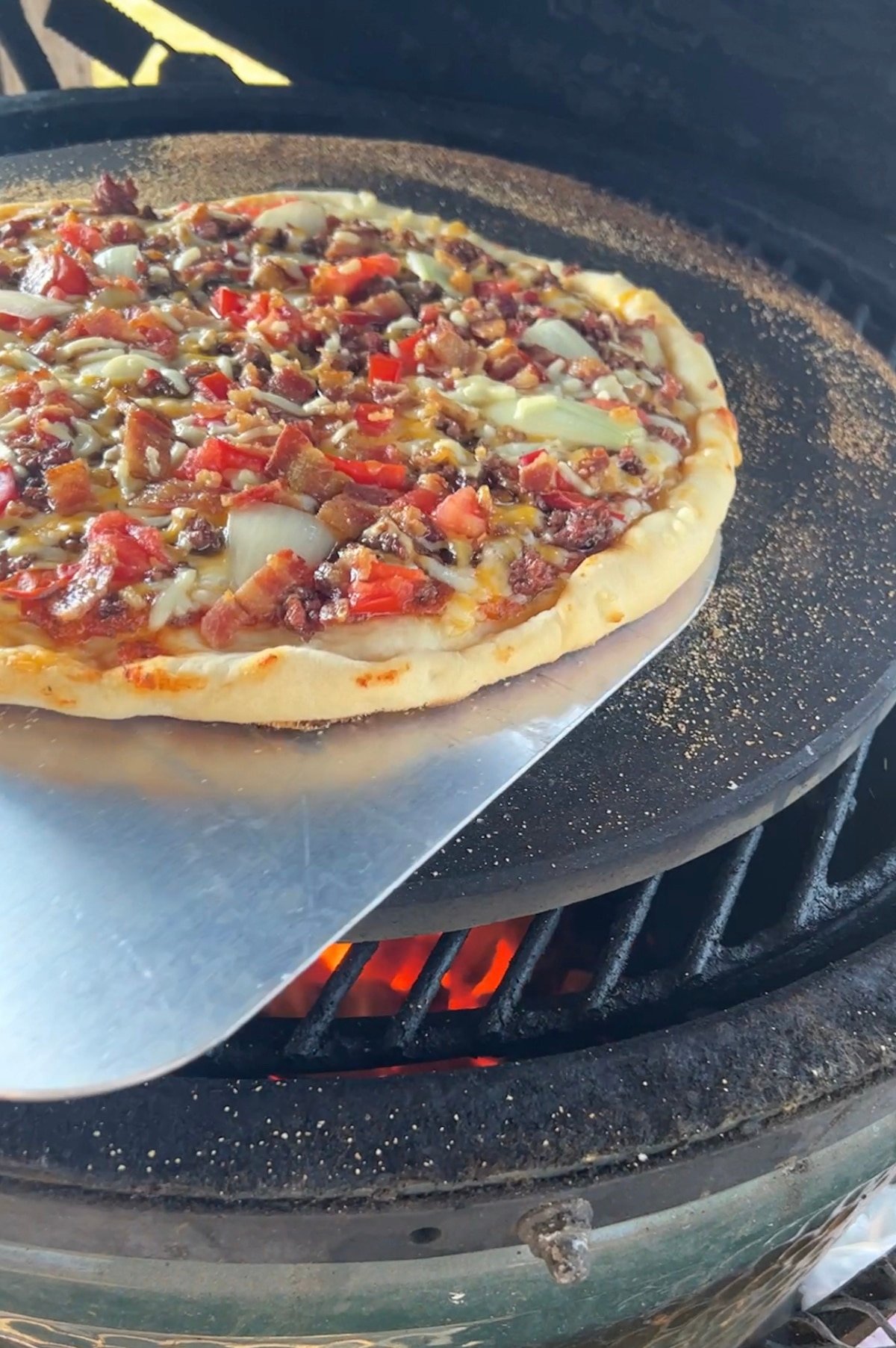Turning pizza on a grill with metal pizza peel.