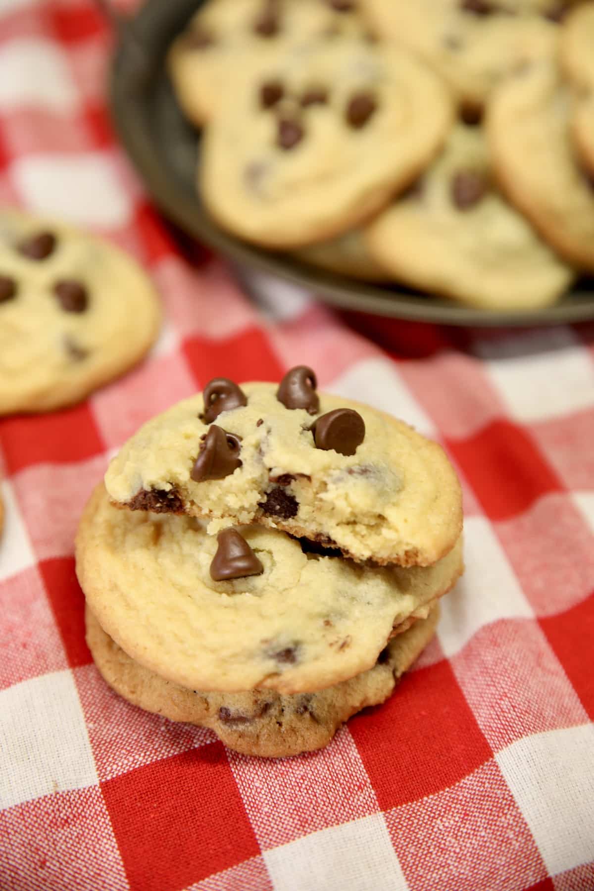 Chocolate chip cookies stacked and on a plate.