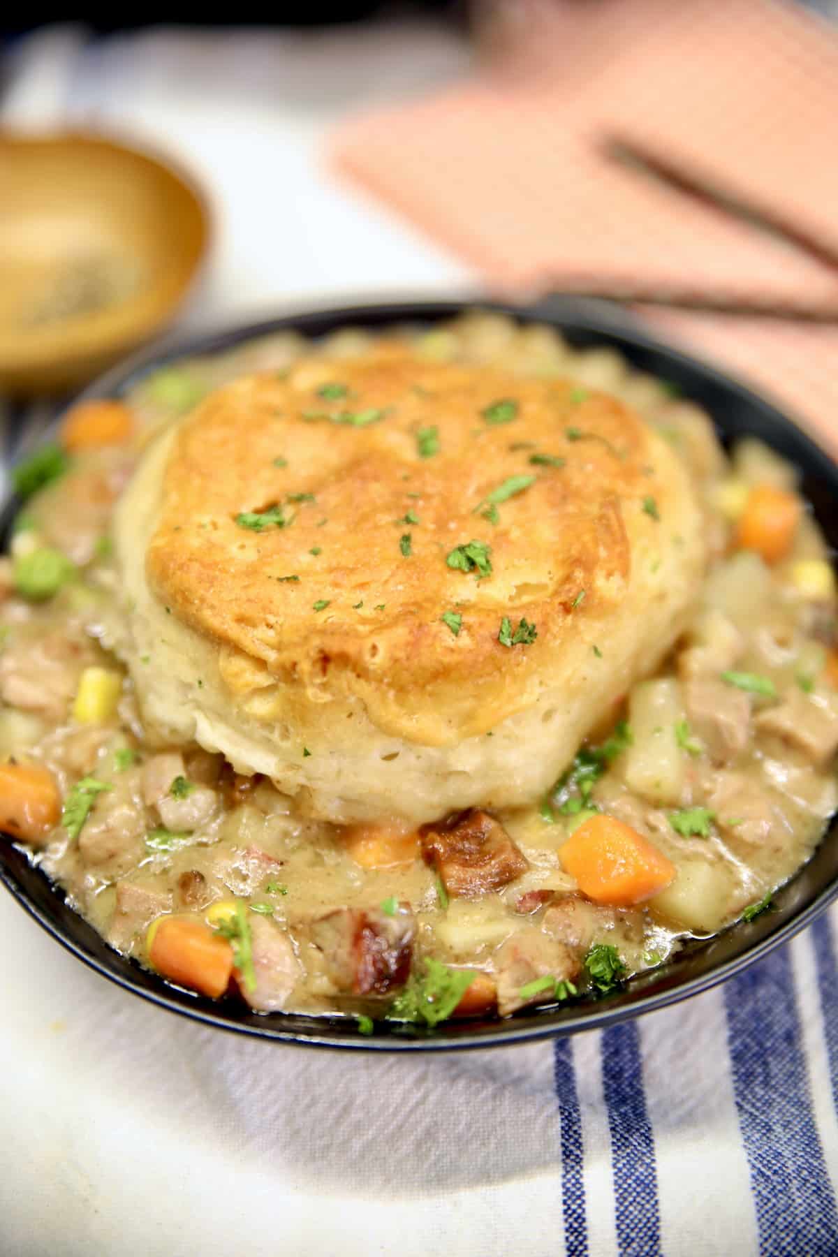 Bowl of beef pot pie with biscuit topping.