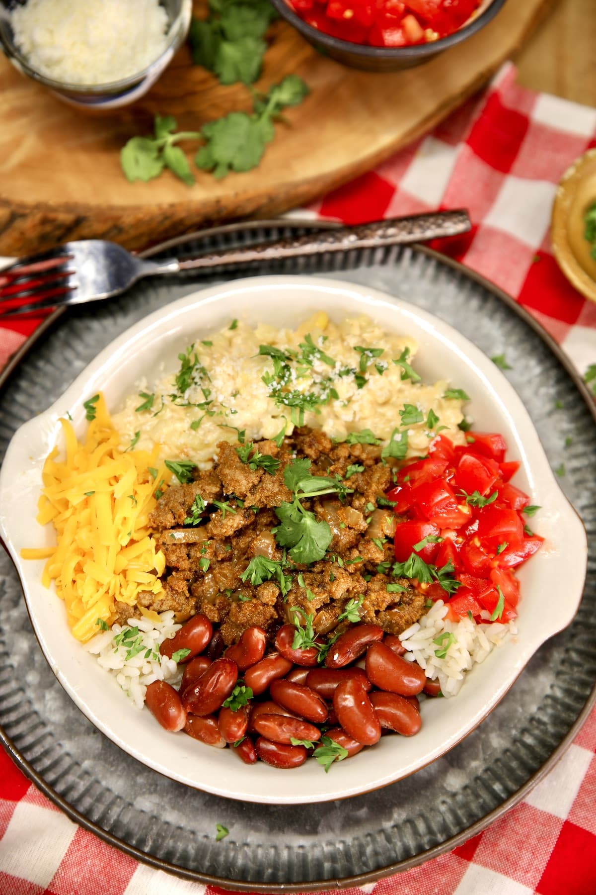 Beef, bean, rice and corn burrito bowl with tomatoes. 