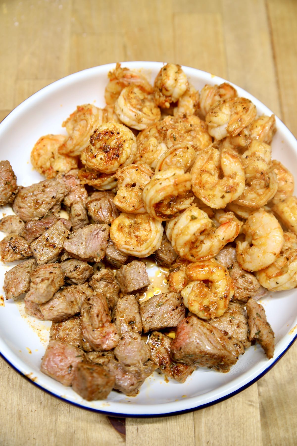 Cajun steak bites and shrimp in a pan.