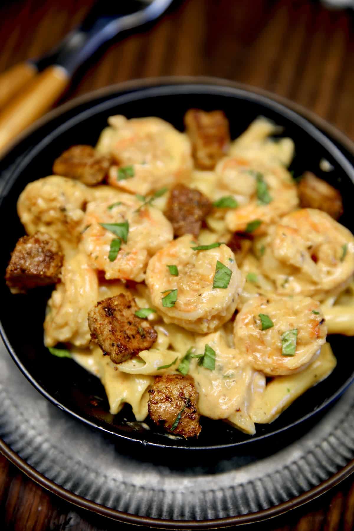 Bowl of pasta with steak and shrimp in a creamy Cajun sauce.