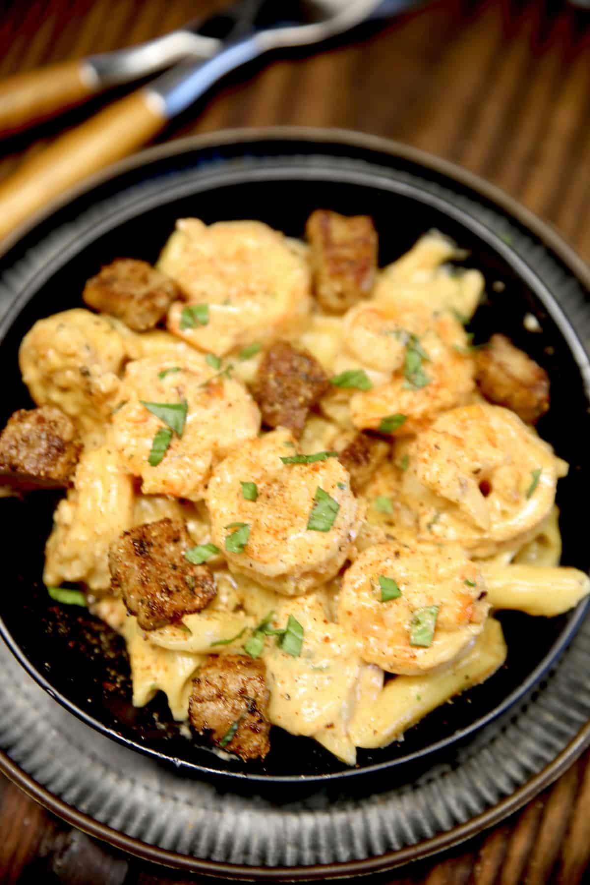 Bowl of pasta with steak and shrimp.