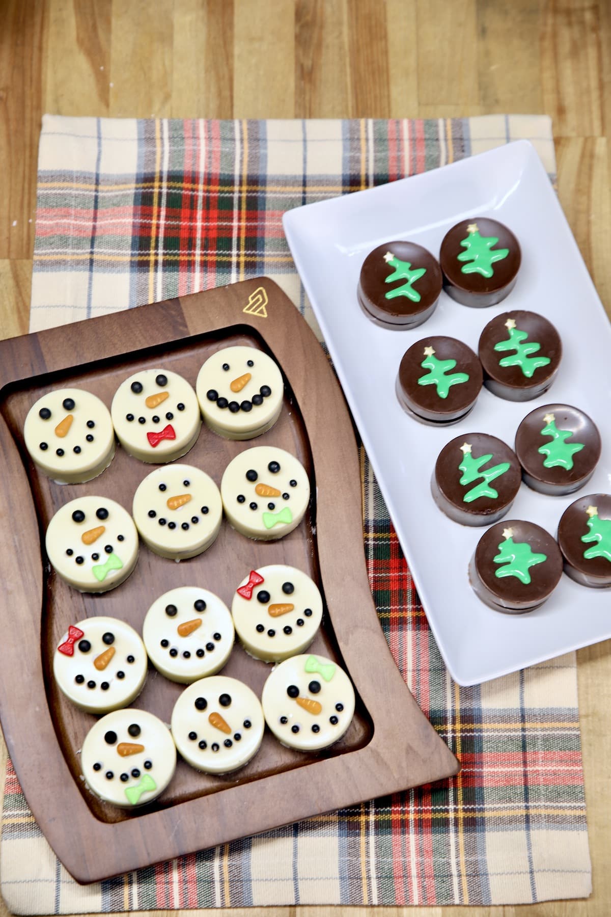 2 platters of Chocolate covered Oreos, Snowmen and Christmas trees.