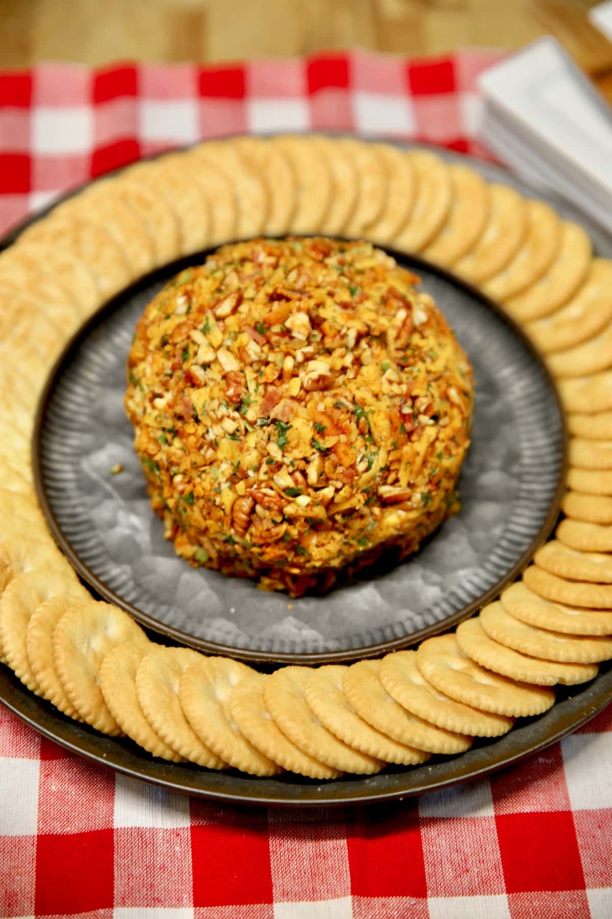 Jalapeno popper cheeseball on a platter with crackers.