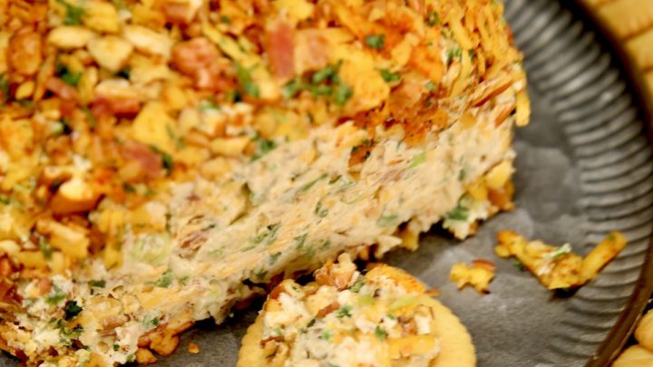 Jalapeno popper cheese ball on a platter with crackers.