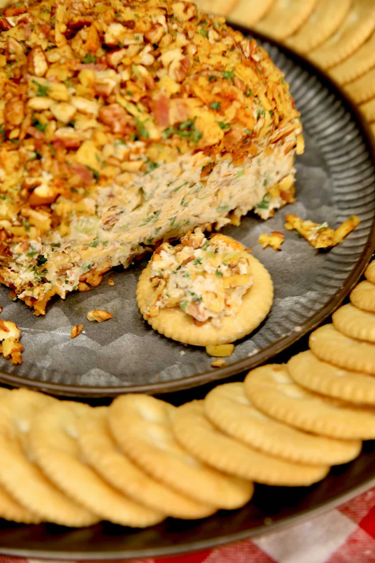 Jalapeno Popper Cheese ball on a platter with crackers.