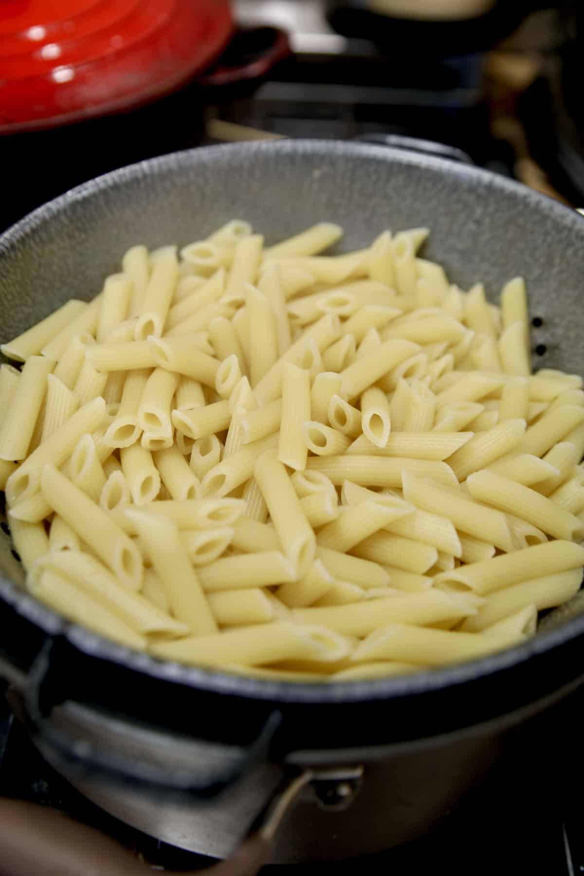 Cooked and drained pasta in a colander.