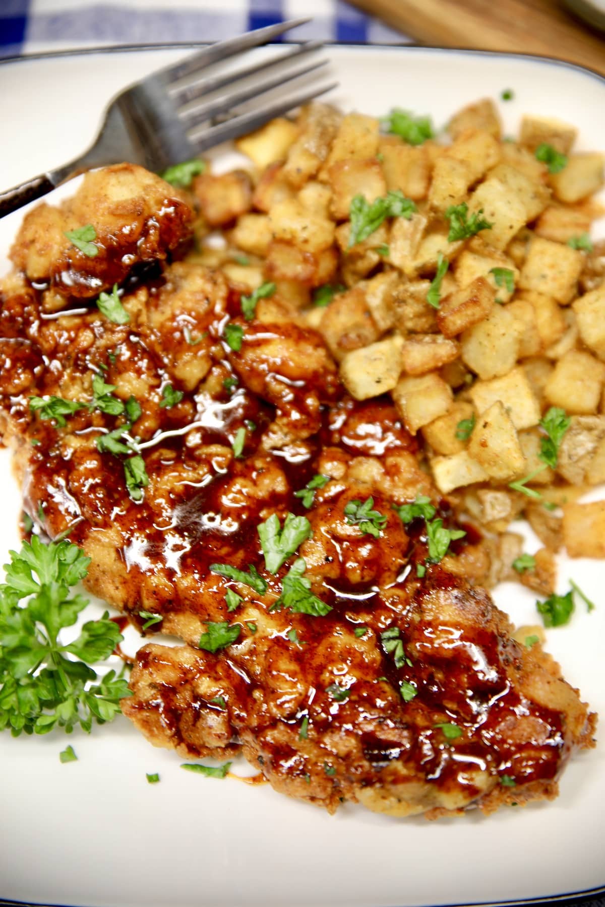 Honey chipotle fried chicken on a plate with cubed potatoes.
