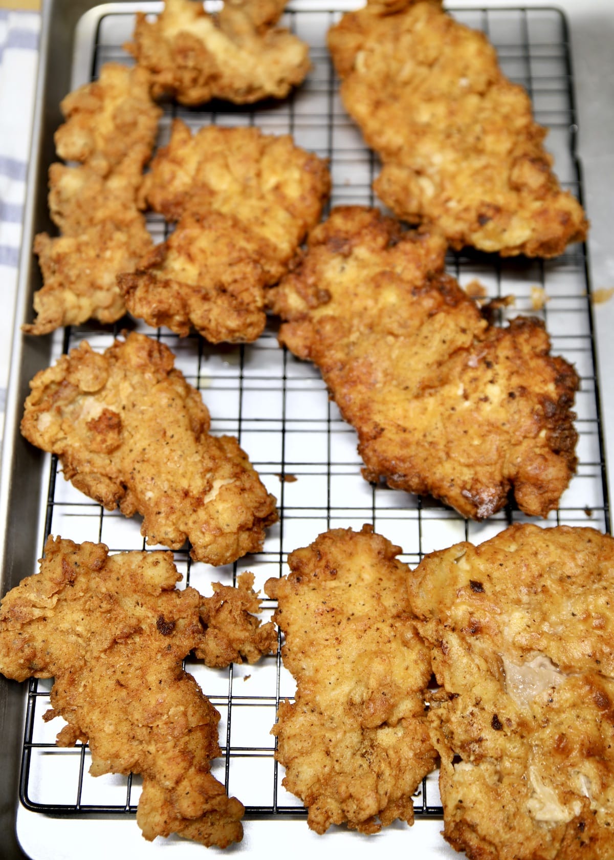 Fried chicken on a wire rack lined pan.