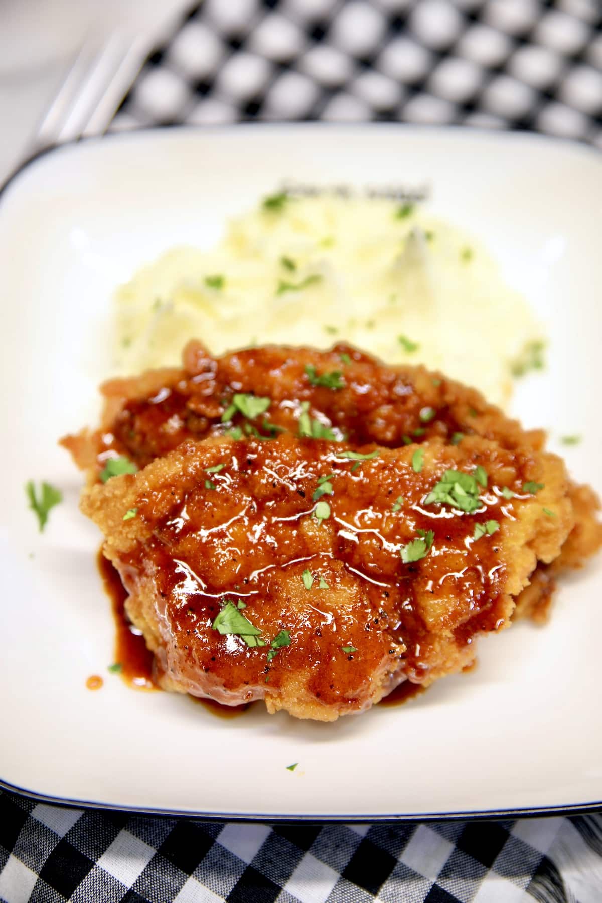 Crispy pork cutlets with honey garlic sauce on mashed potatoes.