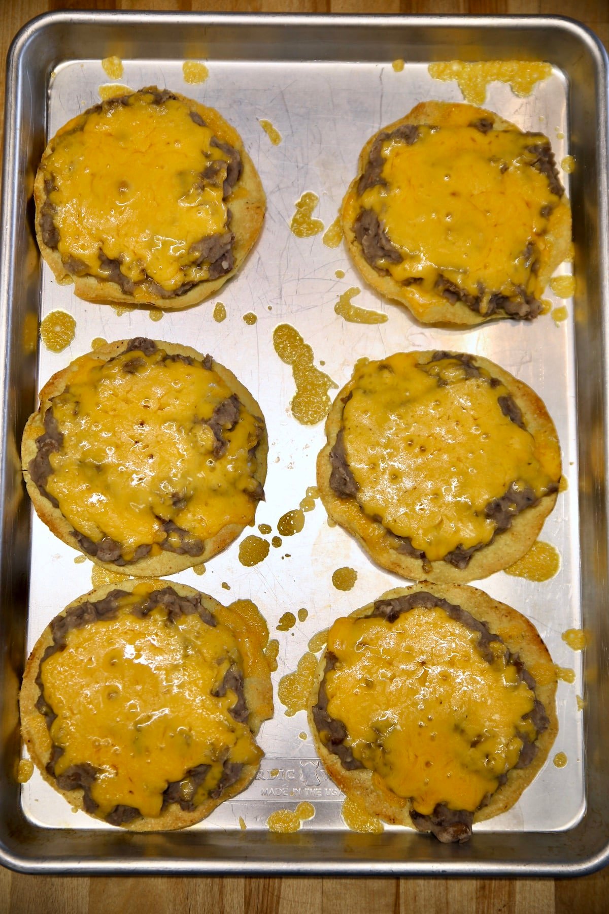 Melted cheese and bean tostadas on a pan.