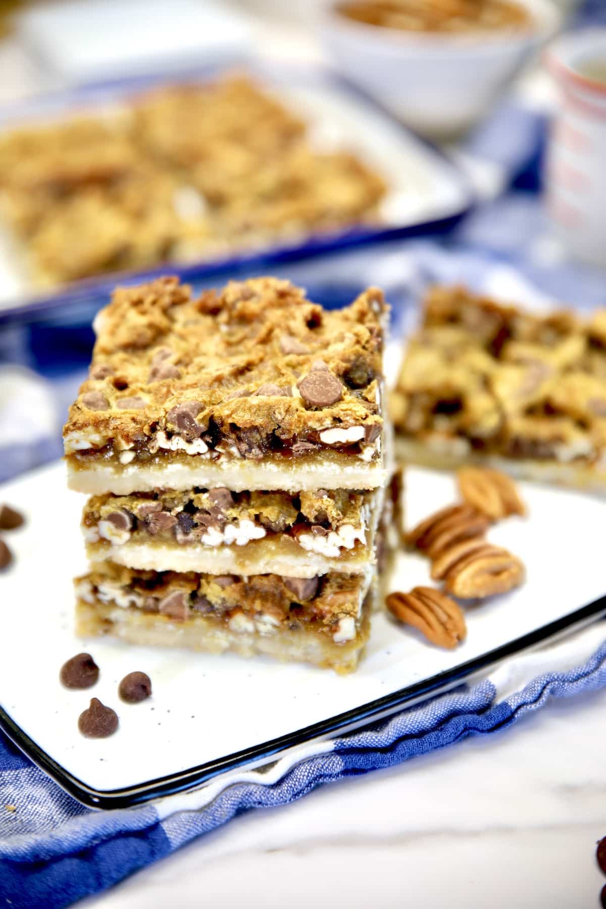 Chocolate pecan bars stacked on a platter.