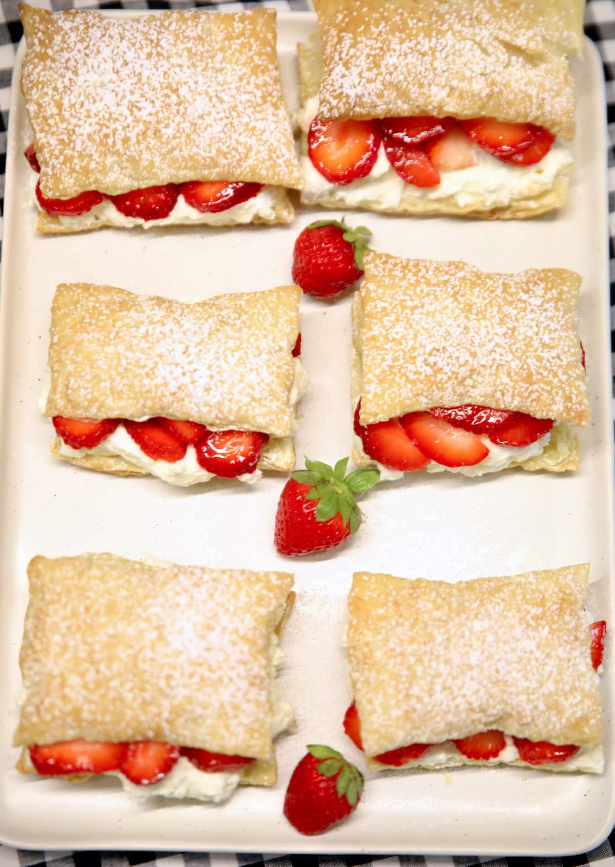 6 puff pastries with strawberry and cream filling.