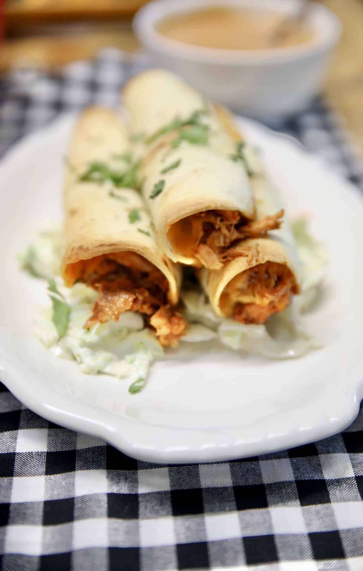 BBQ Chicken Taquitos on a plate with coleslaw.