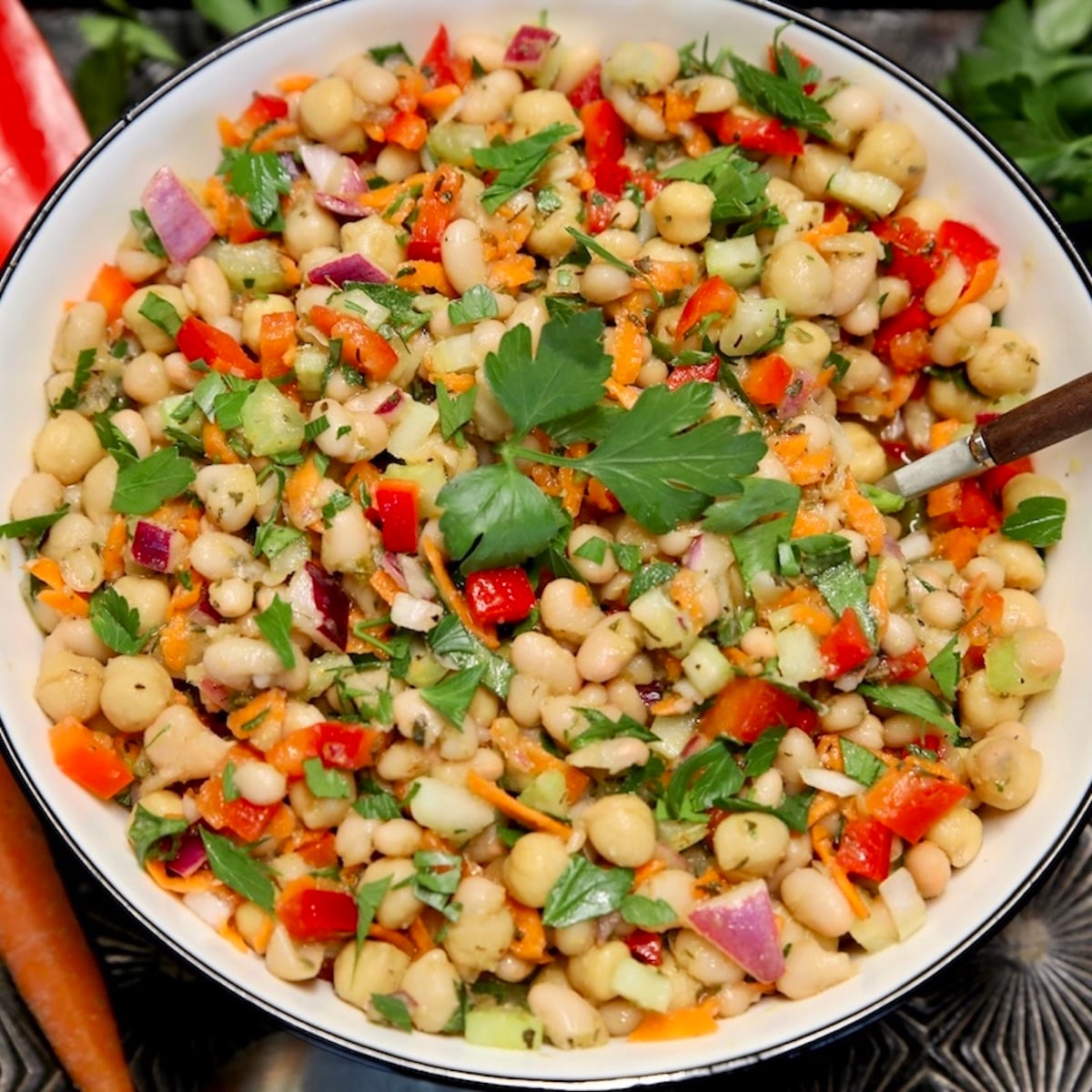 Bowl of white bean salad with s spoon.