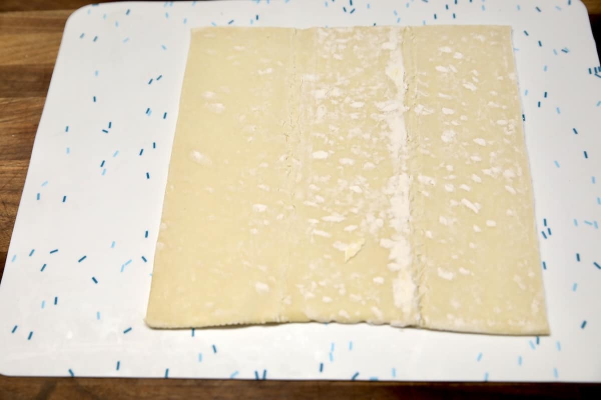 Sheet of puff pastry on silicone mat.