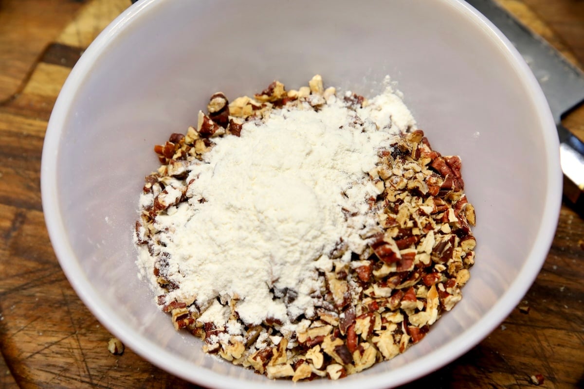 Chopped pecans with flour in a bowl.