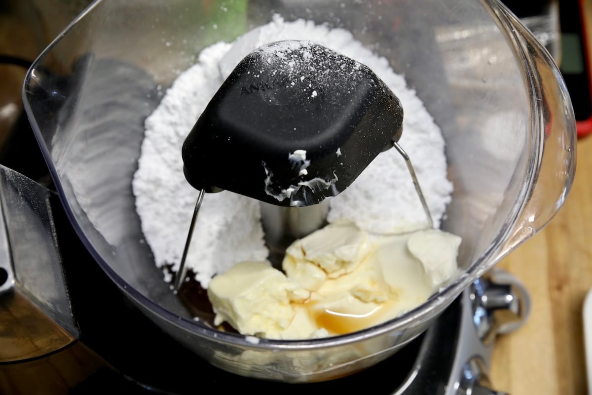 Mixer with cream cheese, powdered sugar, butter, maple syrup.
