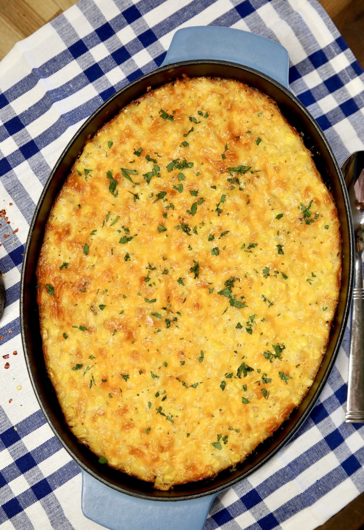 Corn pudding casserole on check cloth.
