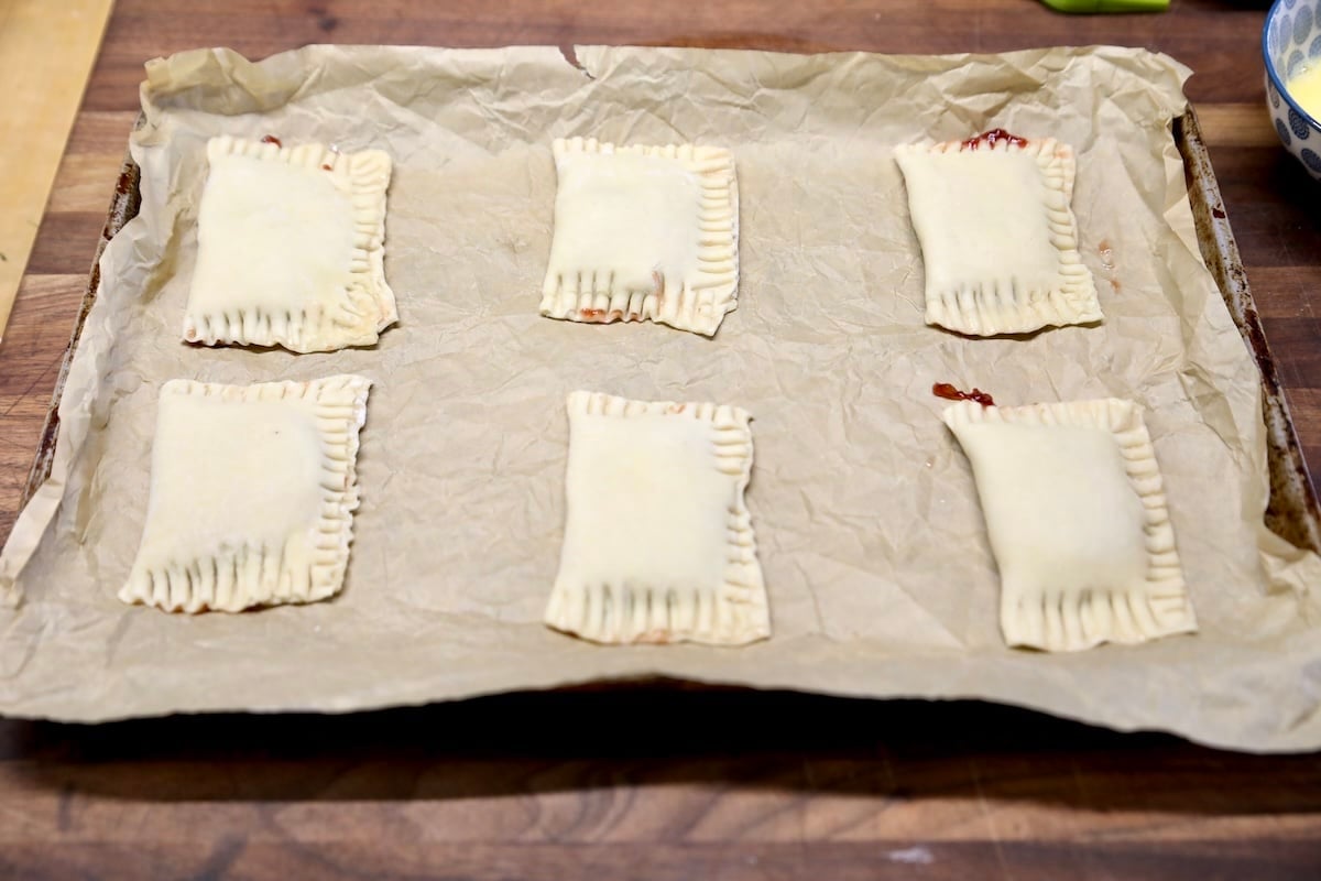 Puff pastry strudel on parchment paper lined baking sheet.