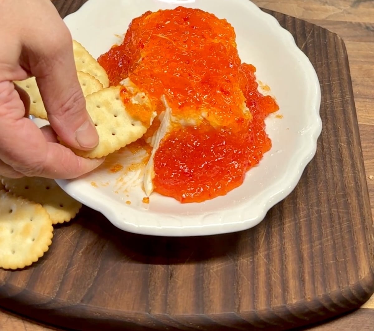 Pepper jelly cream cheese dipping with cracker.