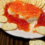 Pepper jelly cream cheese on a platter.