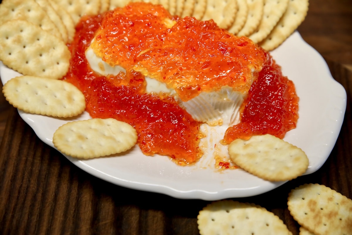 Pepper Jelly Cream Cheese appetizer on a platter with crackers.