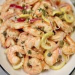 Platter of pickled shrimp with lemon, red onion and capers.