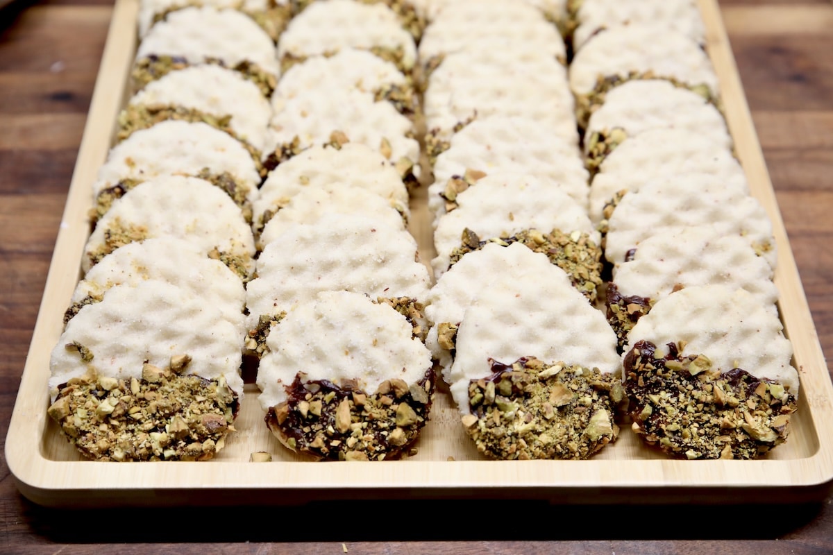 Tray of chocolate dipped cookies with pistachios. Tray of chocolate dipped pistachio cookies.