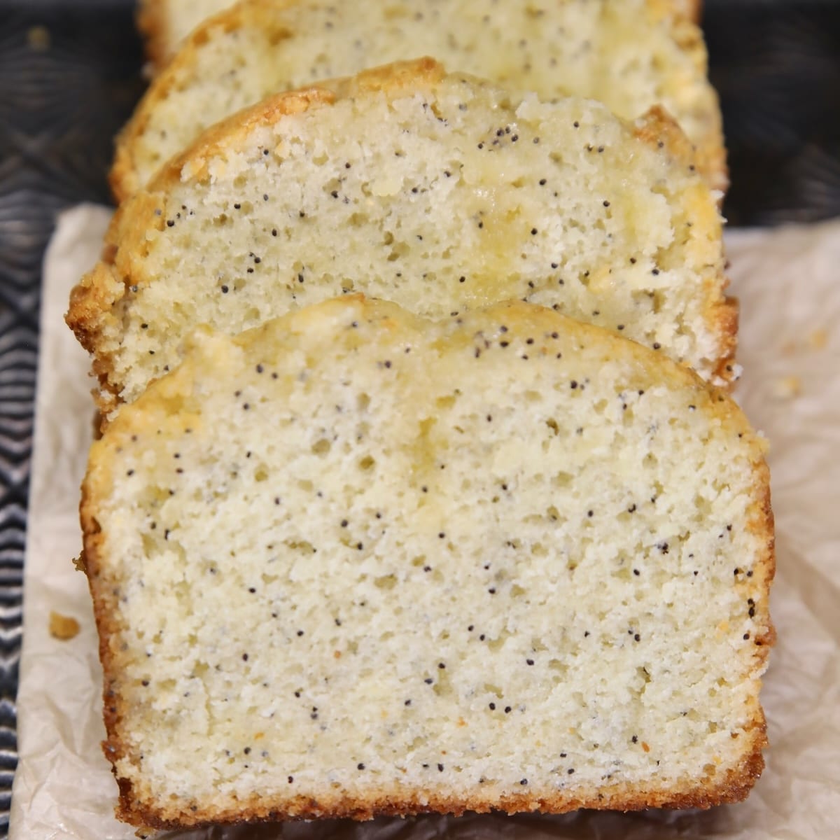 Poppy Seed Bread slices on parchment.