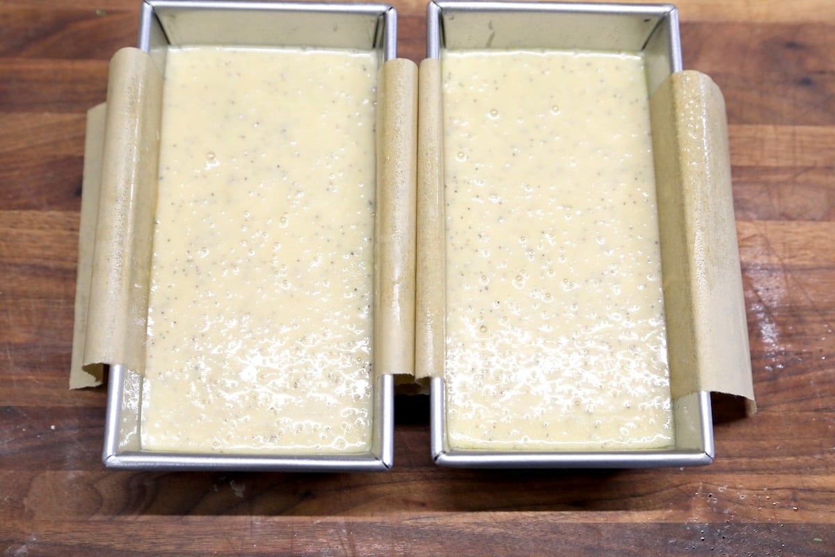 Poppy seed bread batter in 2 loaf pans.