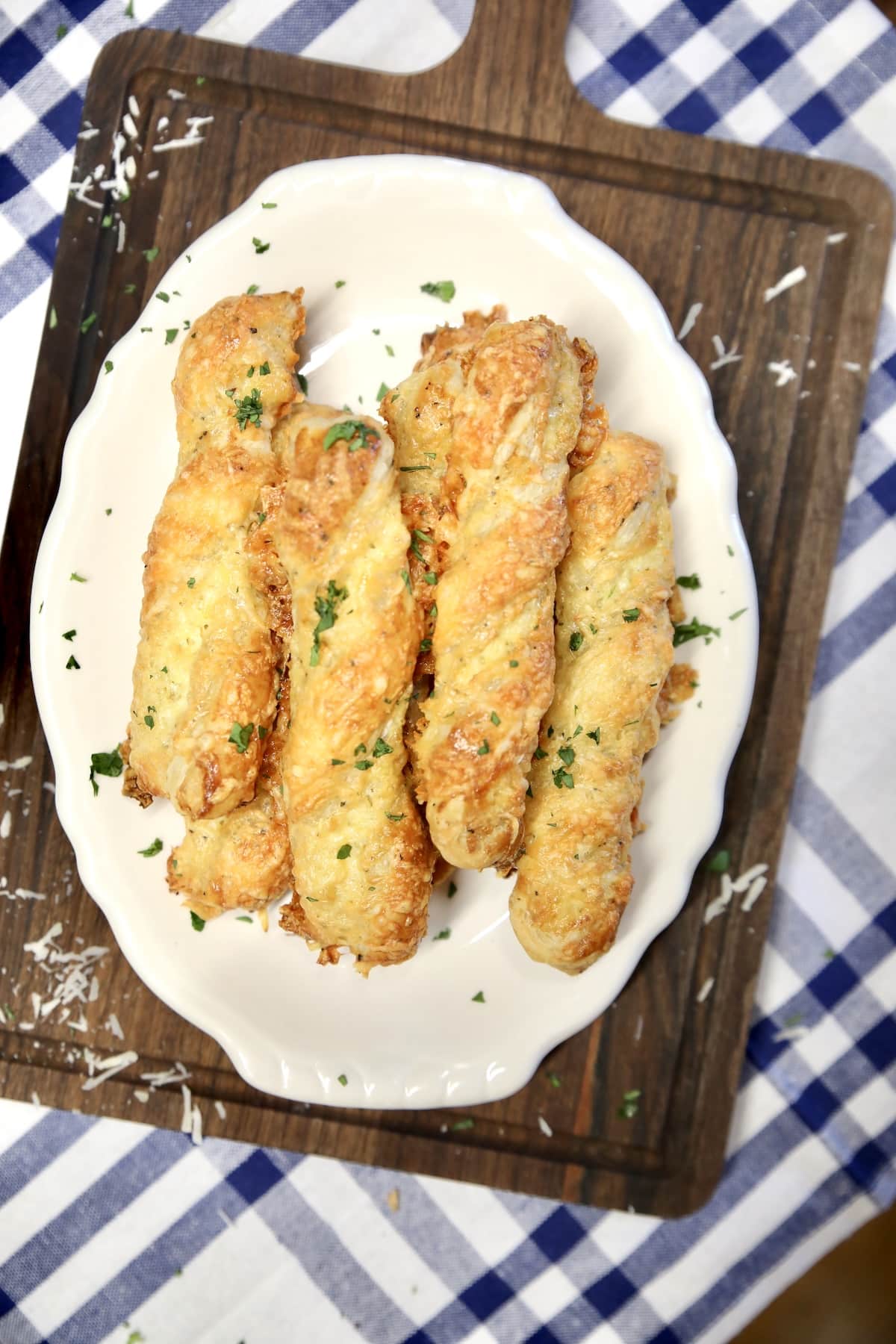 Cheesy puff pastry twists. Platter of puff pastry breadsticks on a platter.