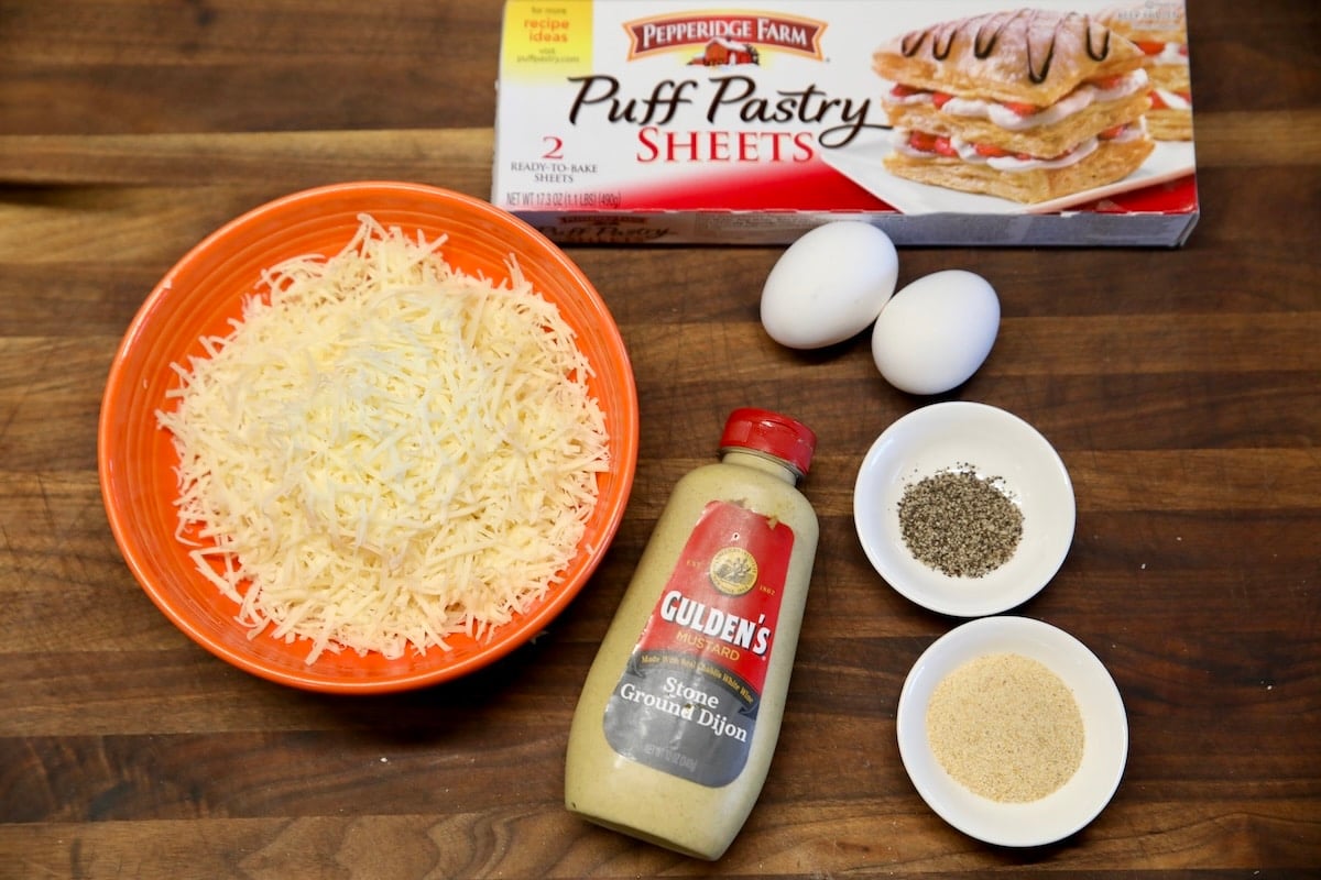 Puff pastry cheese straws ingredients. Cheese, puff pastry, dijon mustard, eggs, garlic, pepper.