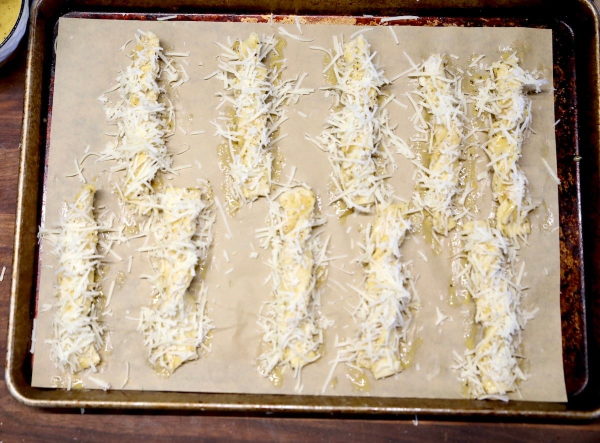 Shredded cheese sprinkled over puff pastry cheese straws.