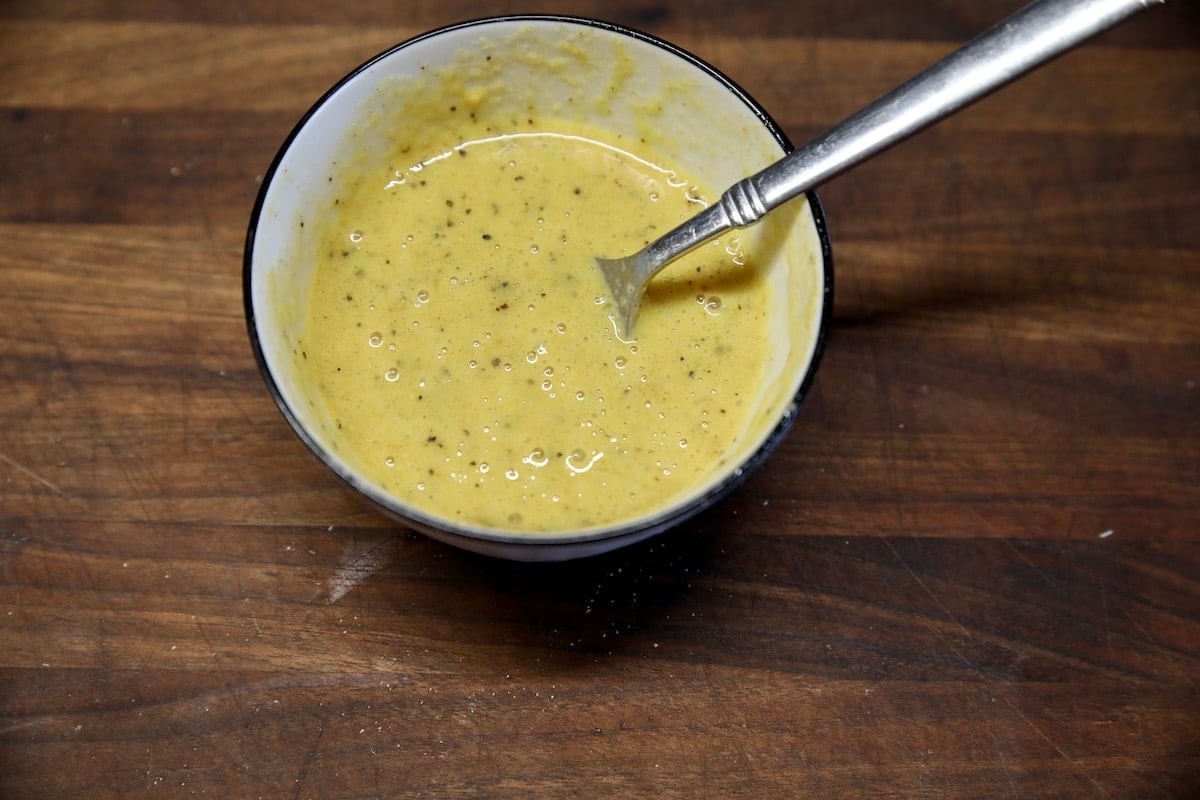 Eggs wash with mustard in a bowl.