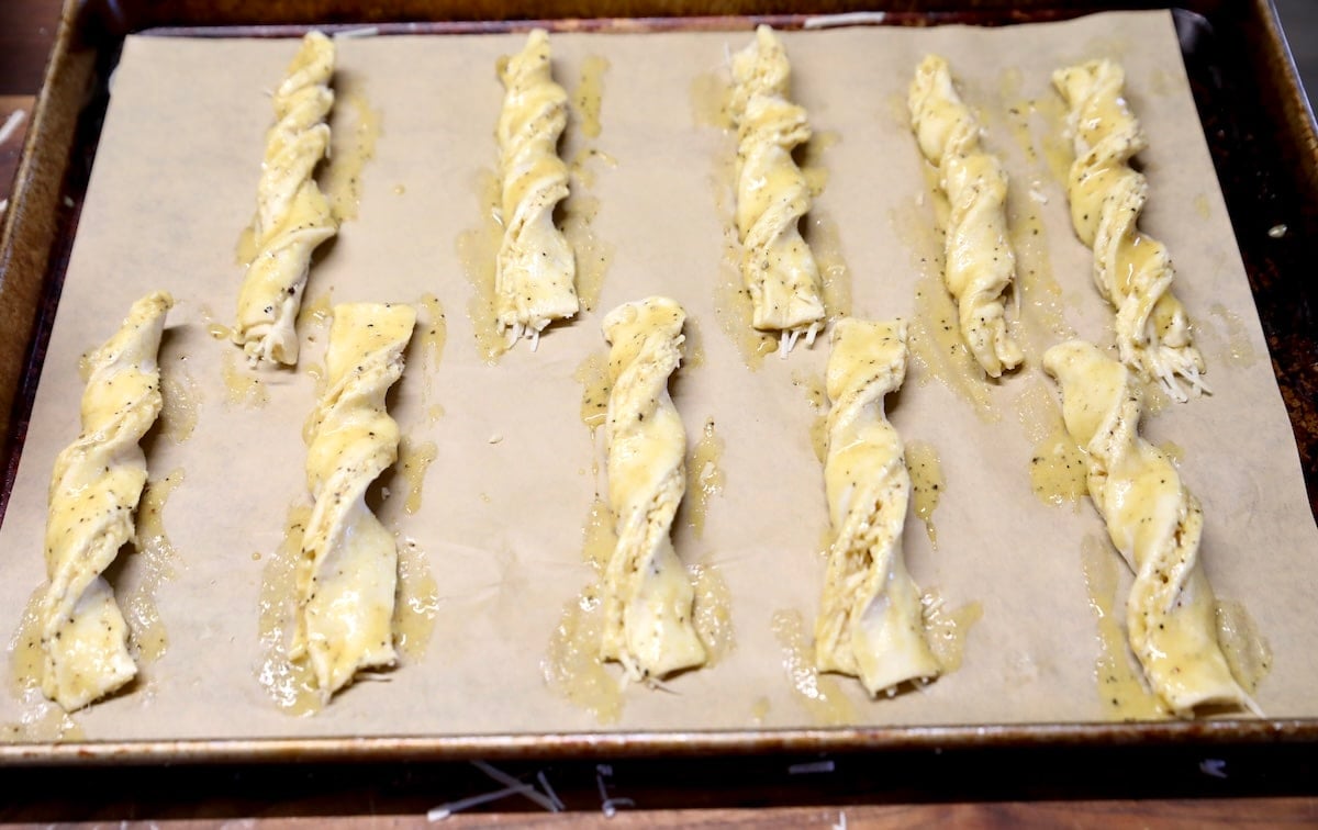 Puff pastry straws brushed with egg wash.